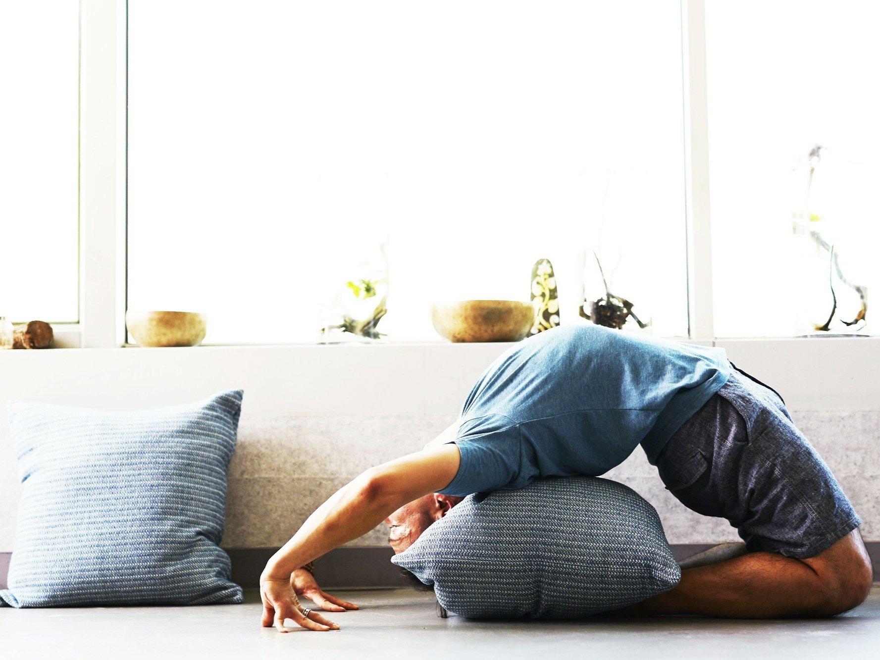 Person doing a back bend over a yoga bolster